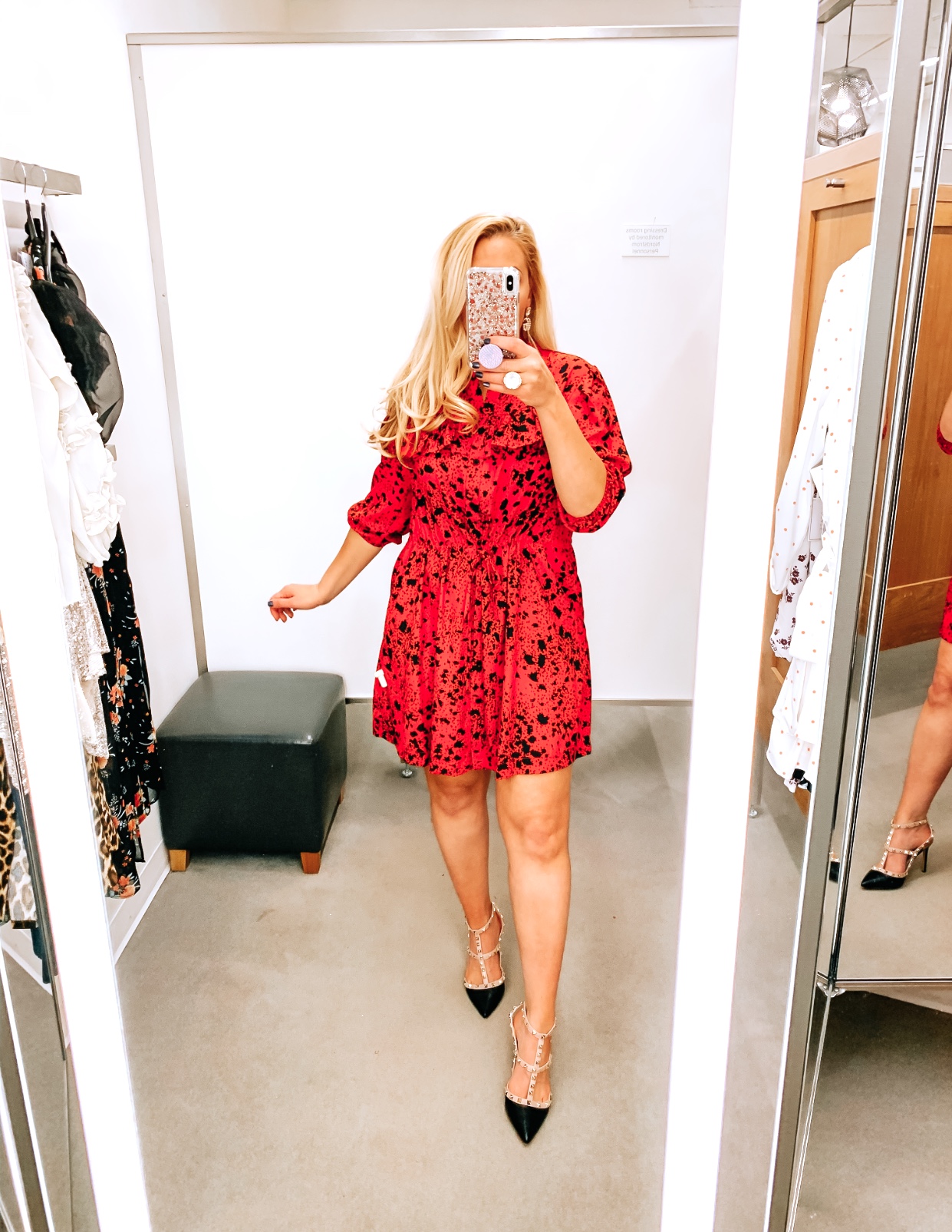 Tampa Blogger Jenn Truman providing a mirror selfie inside Nordstrom at Tampa International Plaza. She is wearing a TOPSHOP Animal Print Tie Waist Mini Shirtdress from Nordstrom and Valentino dupe black studded heels from Amazon. She is holding her phone for a mirror selfie.