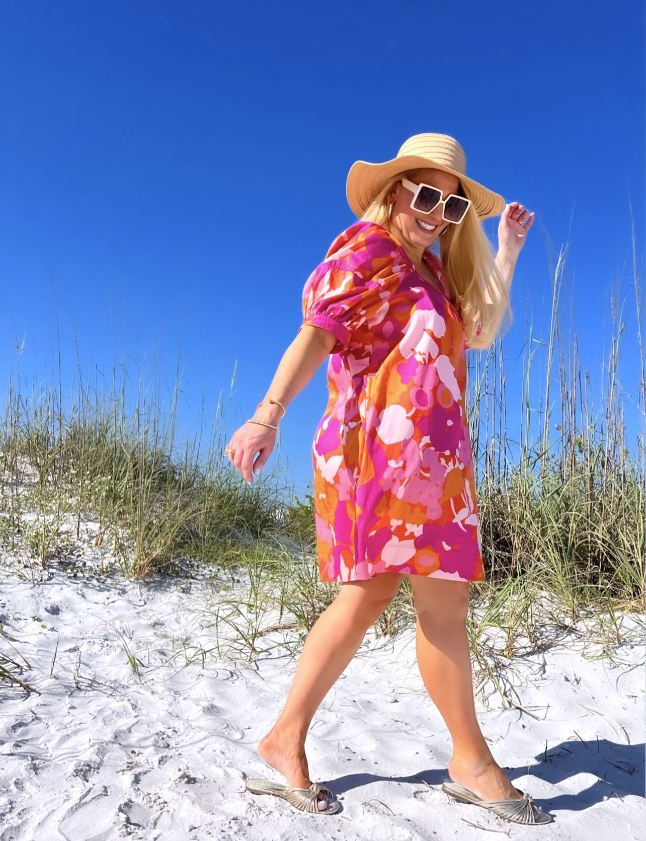 Jenn Truman Fashion Blogger @JTSTJTST11 is walking on the beach in Dunedin Florida while wearing an pink and orange Free Assembly swing dress from Walmart.