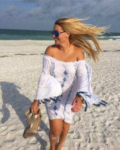 Woman smiling on a windy beach.