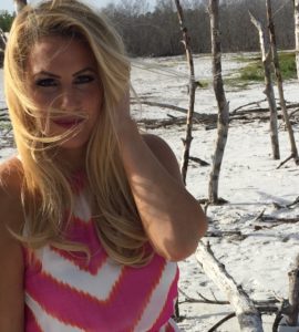 Woman on beach with windswept hair.