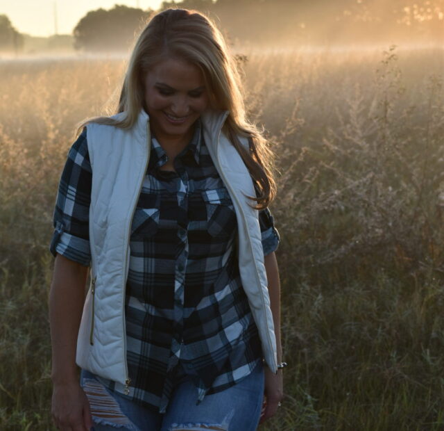 Woman walking in misty field at sunrise.